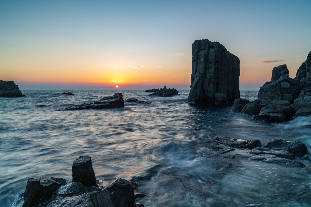 東尋坊の奇岩と夕陽（photo みついしんたろう）