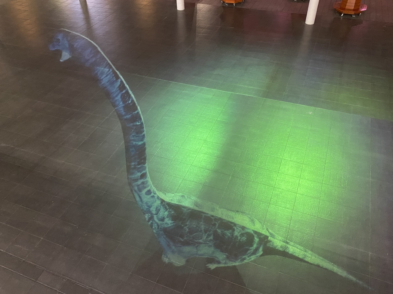 ティラノサウルスの近くのハピテラスではイベントのない夜に３D恐竜のデジタルアートを投影中。