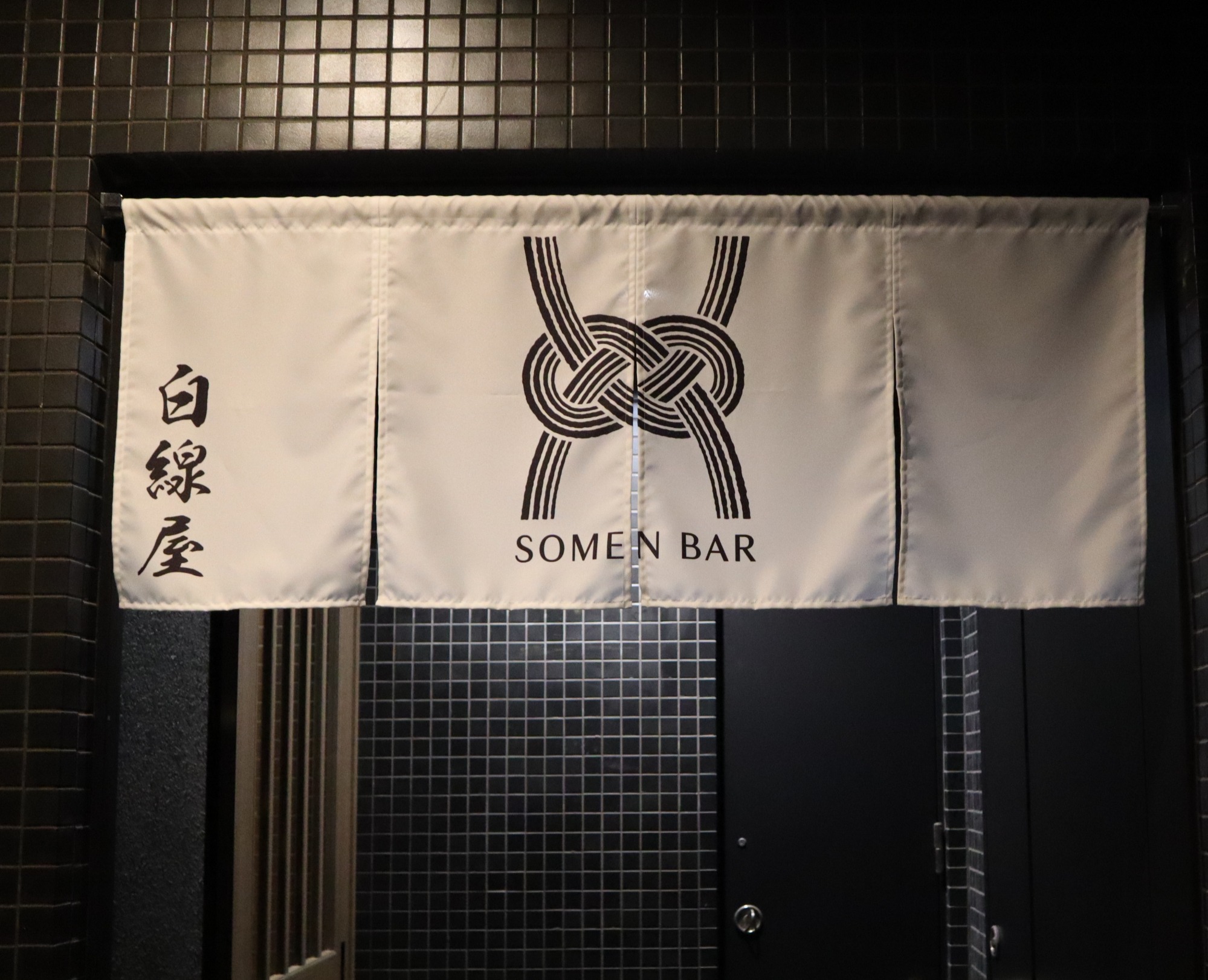 白線屋さんは複合ビルの3階。白く清潔感のある暖簾が目印です