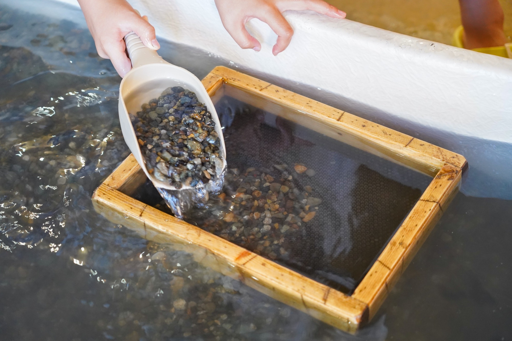 水と石をひとすくいして籠の中へ